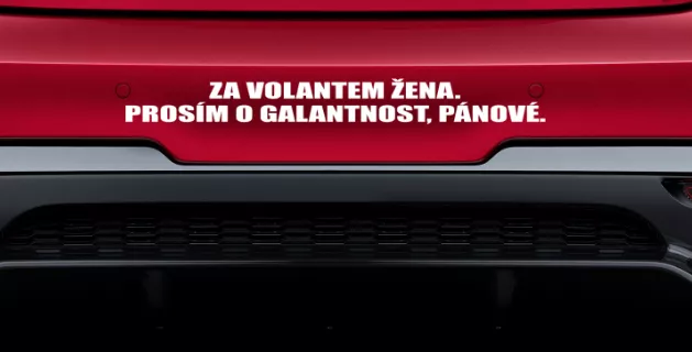 Samolepka: Za volantem žena. Prosím o galantnost, pánové.